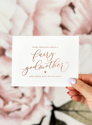 Fairy godmother proposal card with the text 'Every princess needs a fairy godmother, will you be mine?' in elegant script lettering. Perfect for godmother proposal occasions.